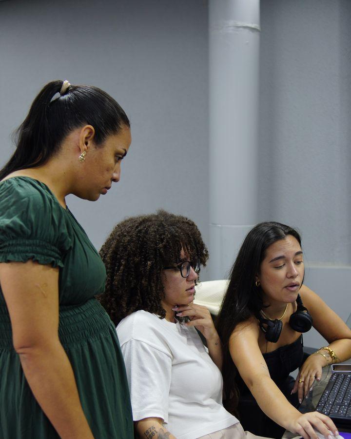 Três pessoas da equipe da MPC conferindo um trabalho no computador, no escritório em Belo Horizonte