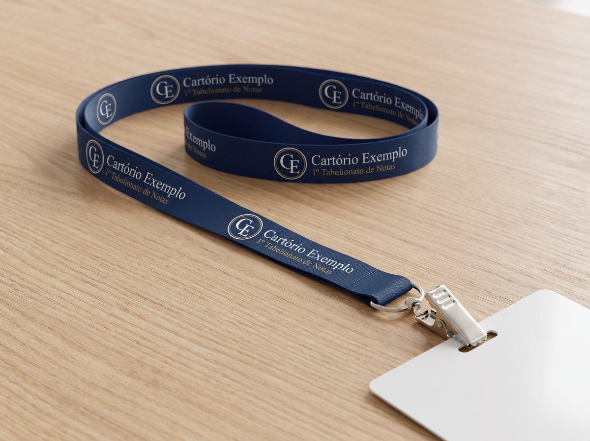 Cordão azul de 1,5 cm com o logo de um cartório fictício e fecho jacaré prendendo um crachá (imagem ilustrativa)