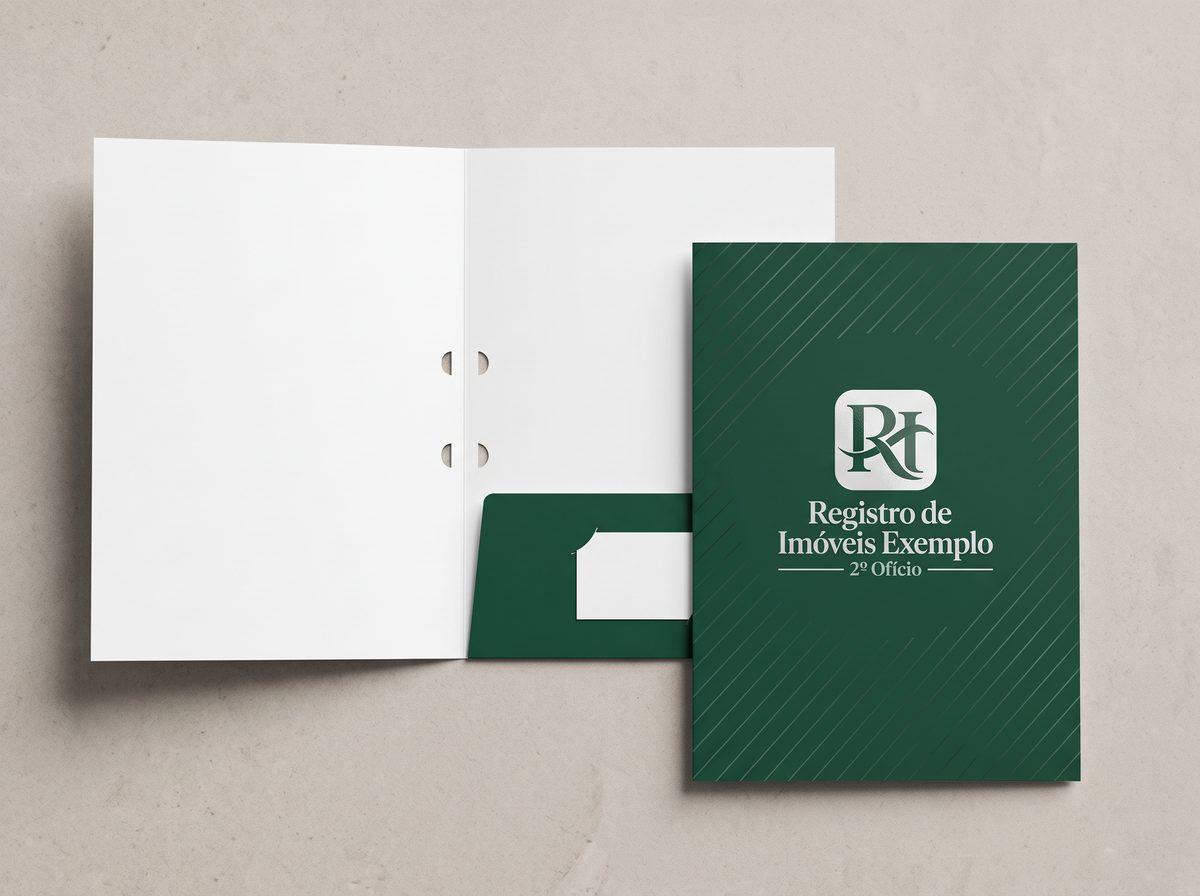 Pastas verde-escuras foscas com o logo de um registro de imóveis fictício e listras em verniz localizado, uma fechada e outra aberta com a bolsa verde segurando um cartão de visita